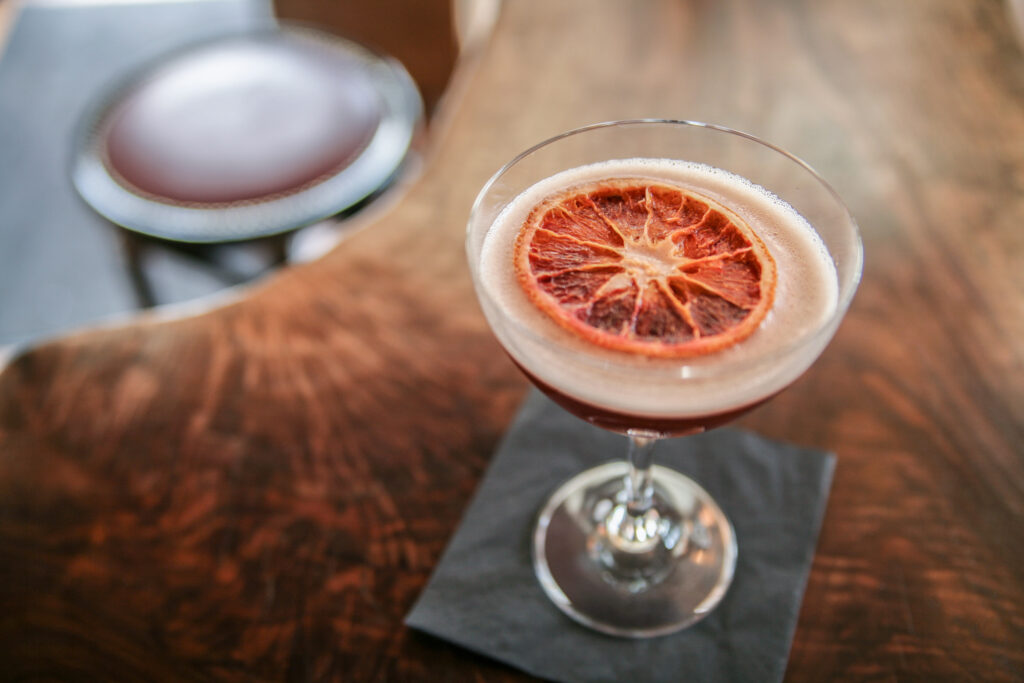 Craft cocktail with blood orange garnish at the venue bar