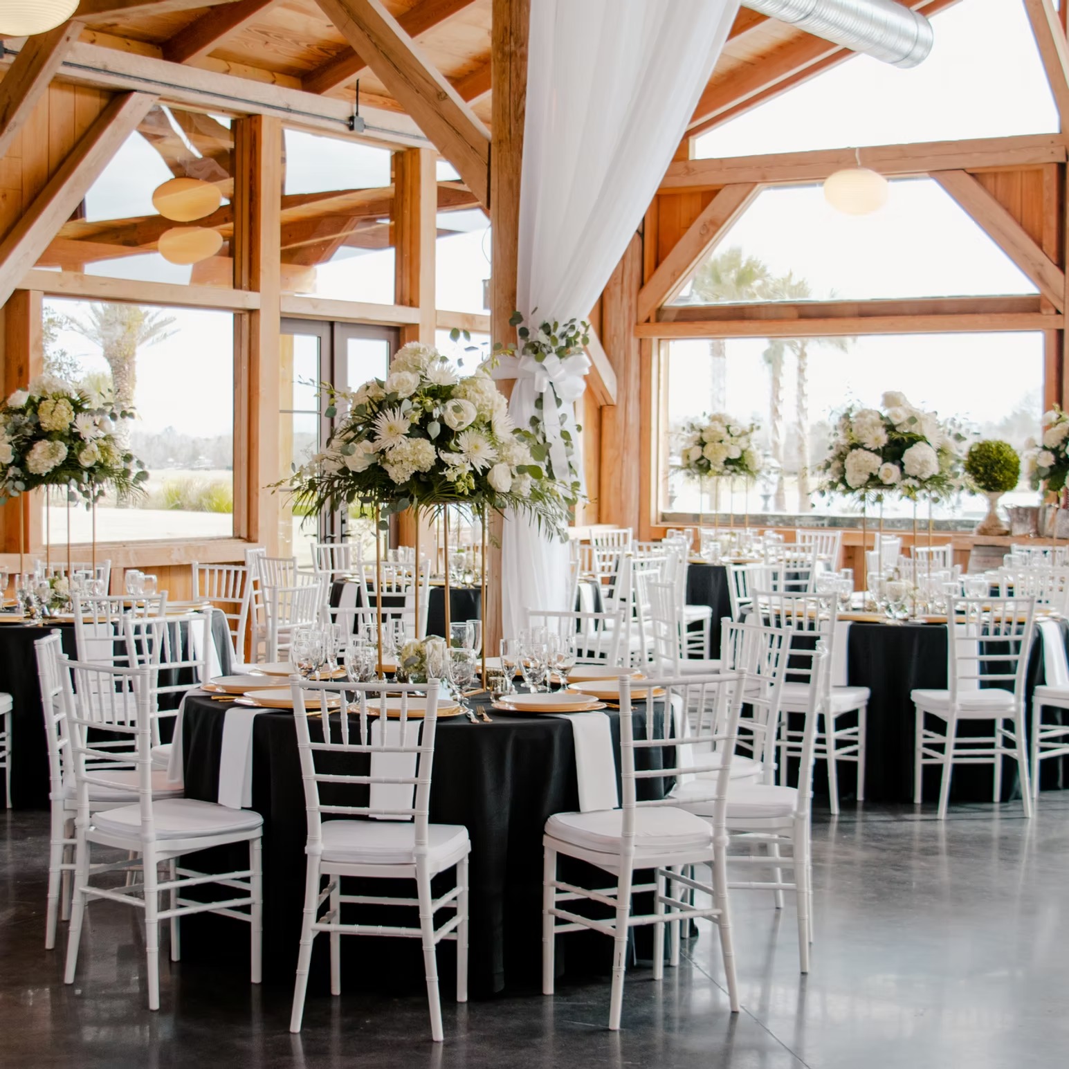 Reception tables with white chairs and floral centerpieces in the main hall