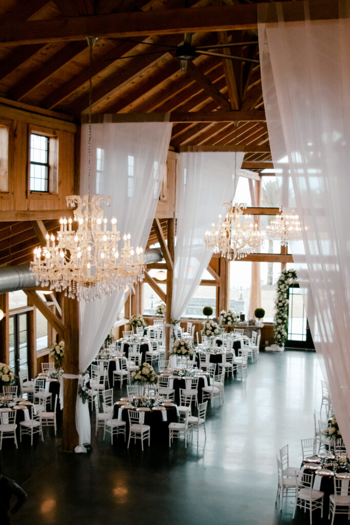 Main hall with chandeliers and white drapery set for a wedding reception