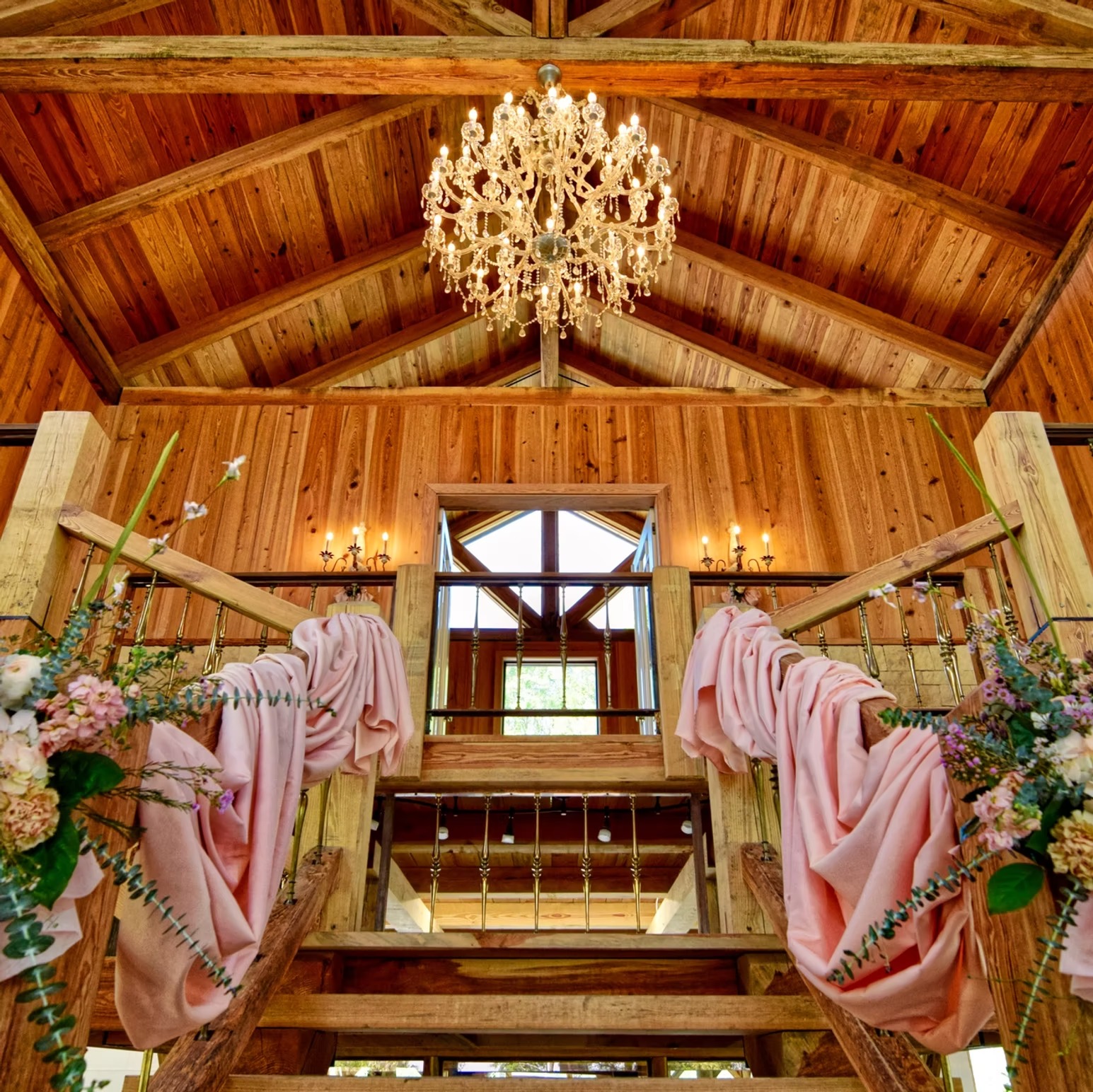 Chandelier and blush drapery on the loft staircase inside The Barn at Cottonwood Ranch