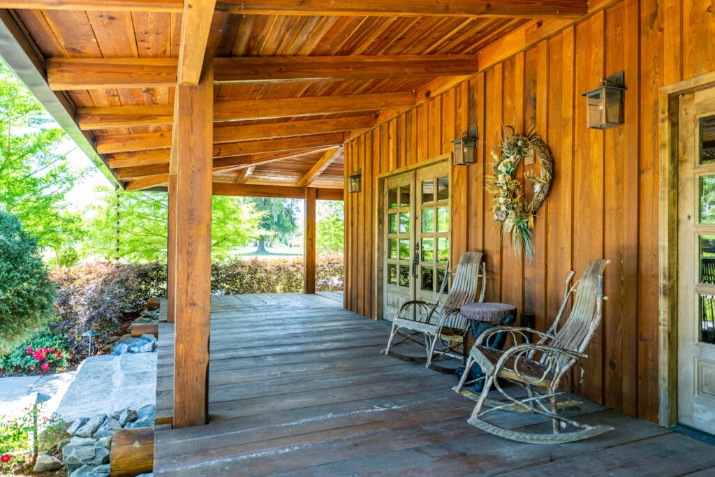 Covered wood porch with rocking chairs overlooking the ranch