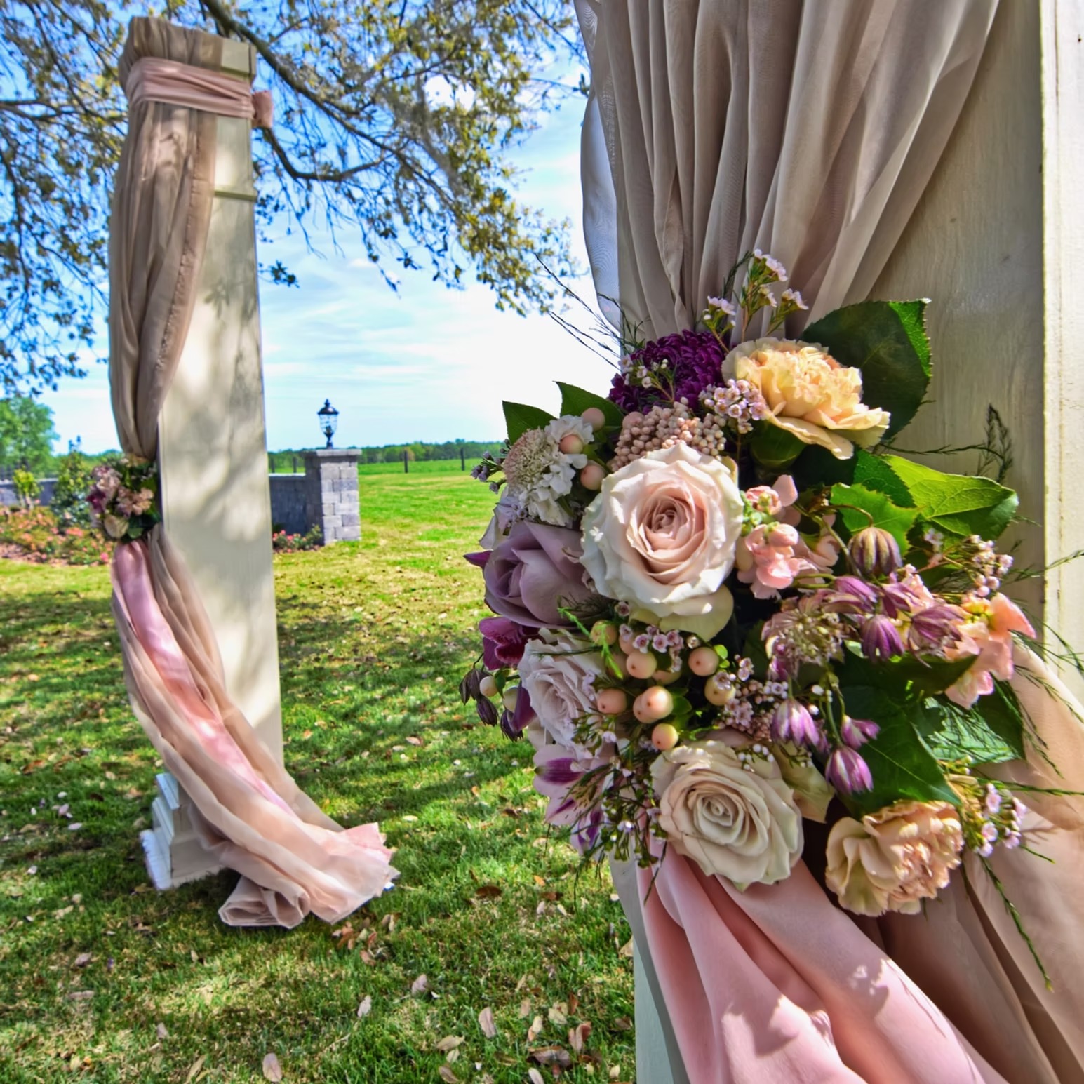 Wedding ceremony florals and blush drapery outdoors at Cottonwood Ranch